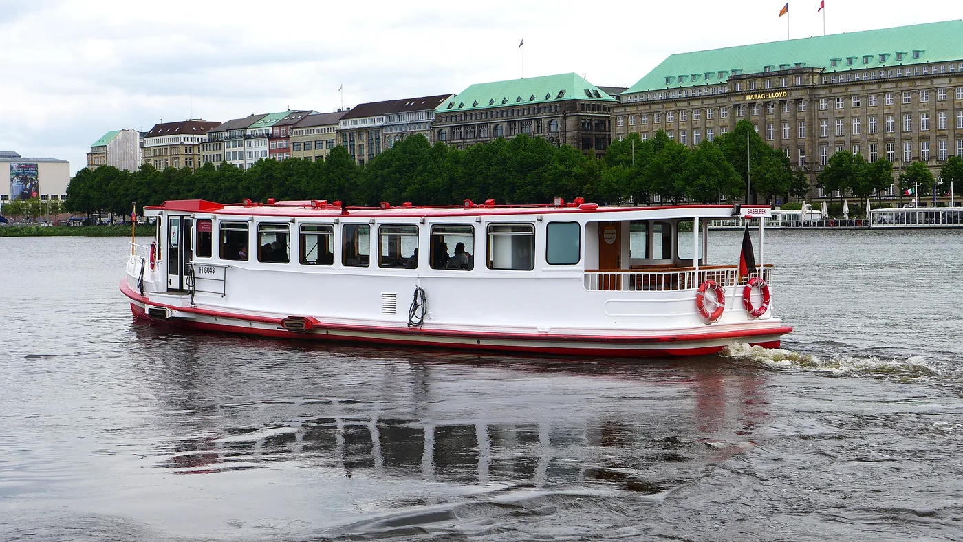 Weißroter Alsterdampfer auf der Binnenalster vor der Bebauung am Ballindamm