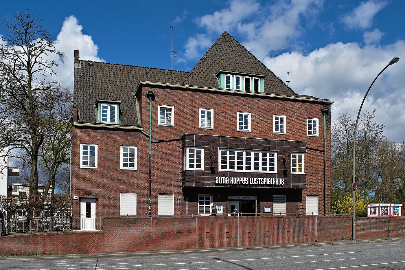 Das Lustspielhaus von der Straßenseite mit Bäumen davor