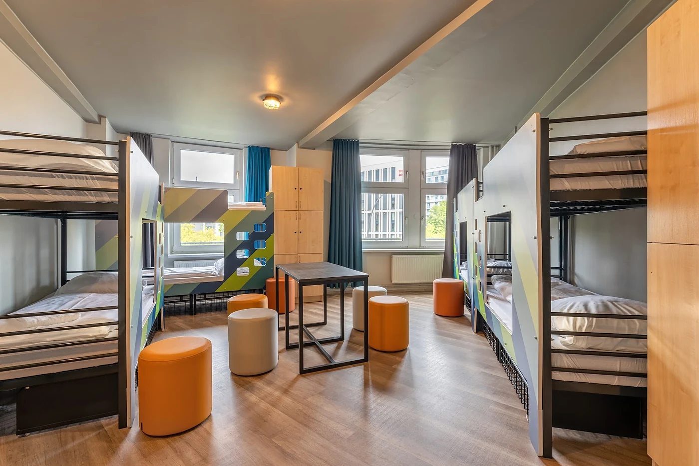 Mehrbettzimmer mit Etagenbetten und Sitzecke am Fenster