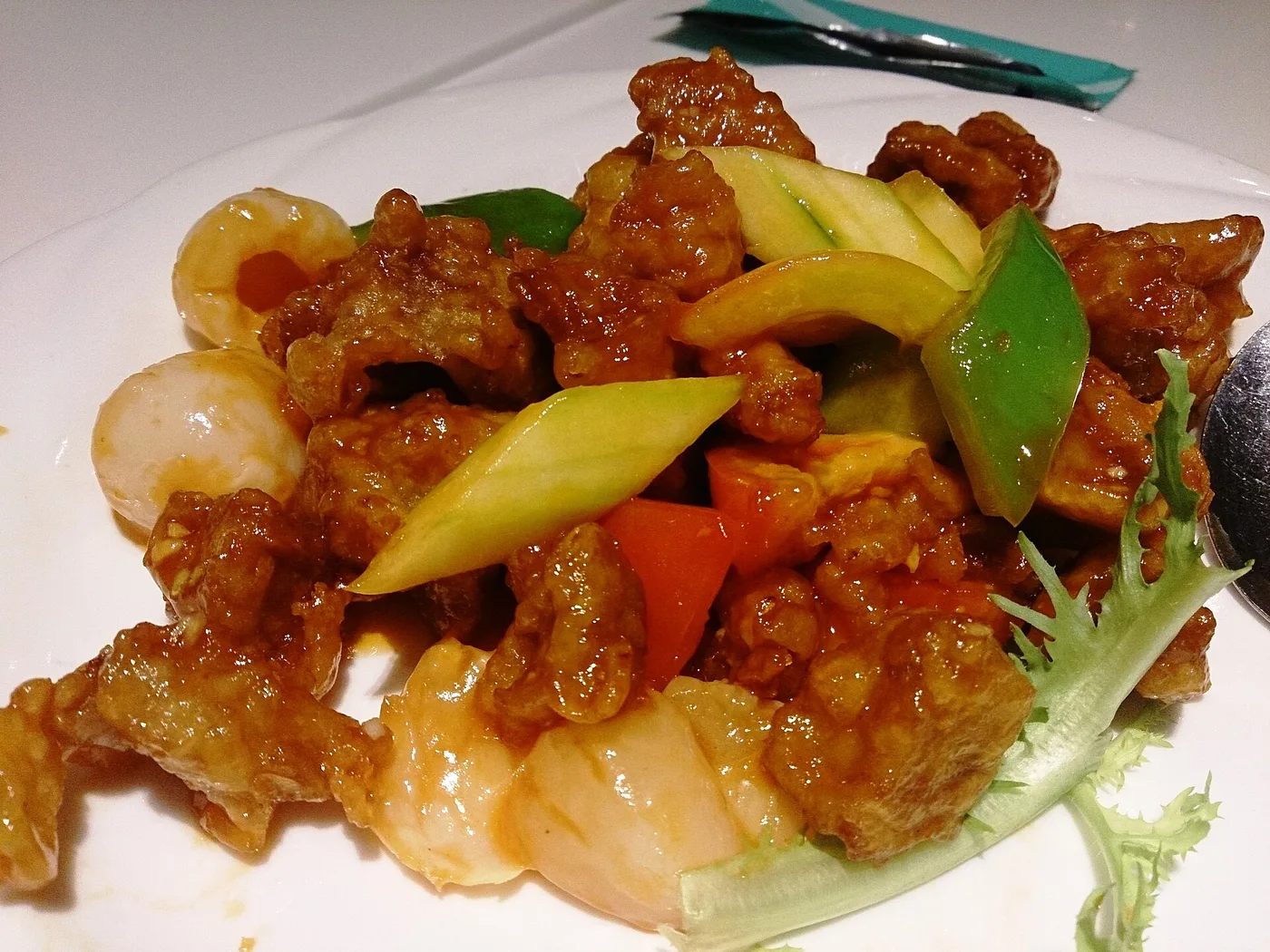 Süßsaures Schweinefleisch mit Paprika und Gemüse auf weißem Teller
