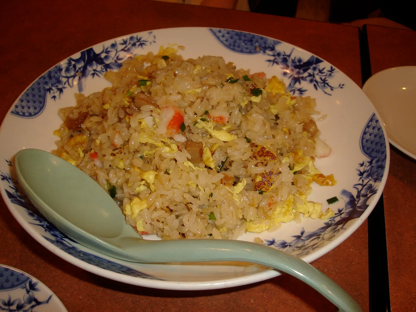 Gebratener Reis mit Ei und Frühlingszwiebeln in einer blauweißen Porzellanschale
