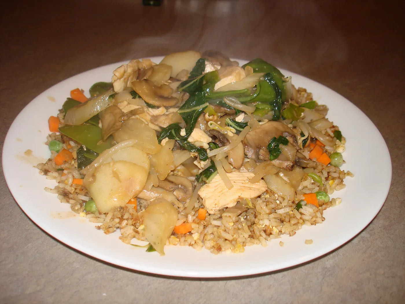 Chop Suey mit Hühnchen und Gemüse auf gebratenem Reis