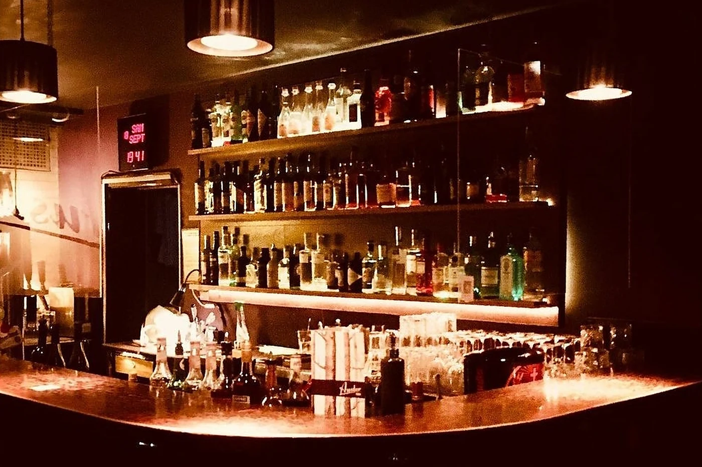Beleuchtetes Flaschenregal hinter dem Tresen der Auster Bar im warmen Licht
