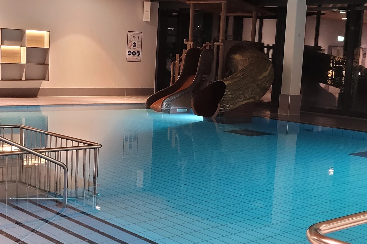 Schwimmhalle mit Becken unter einer Holzdecke