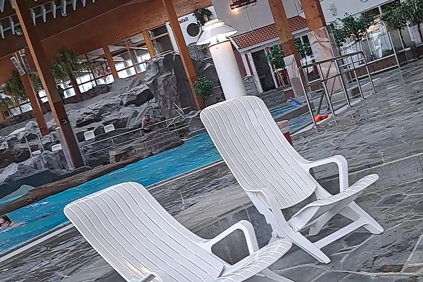 Liegestühle auf einer Terrasse am Beckenrand