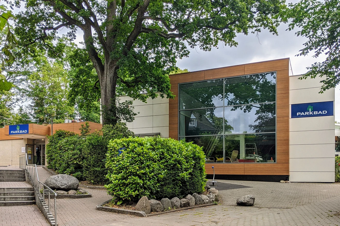 Moderner Eingangsbau des Parkbads mit Holzverkleidung und Schriftzug Parkbad