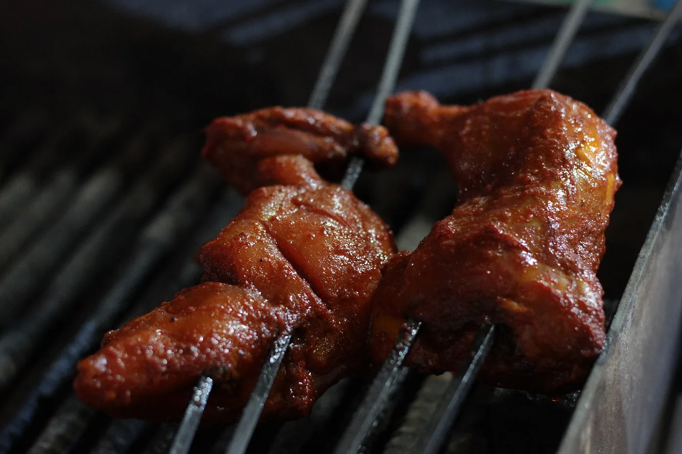 Rot mariniertes Tandoori-Hähnchen auf dem Grillrost