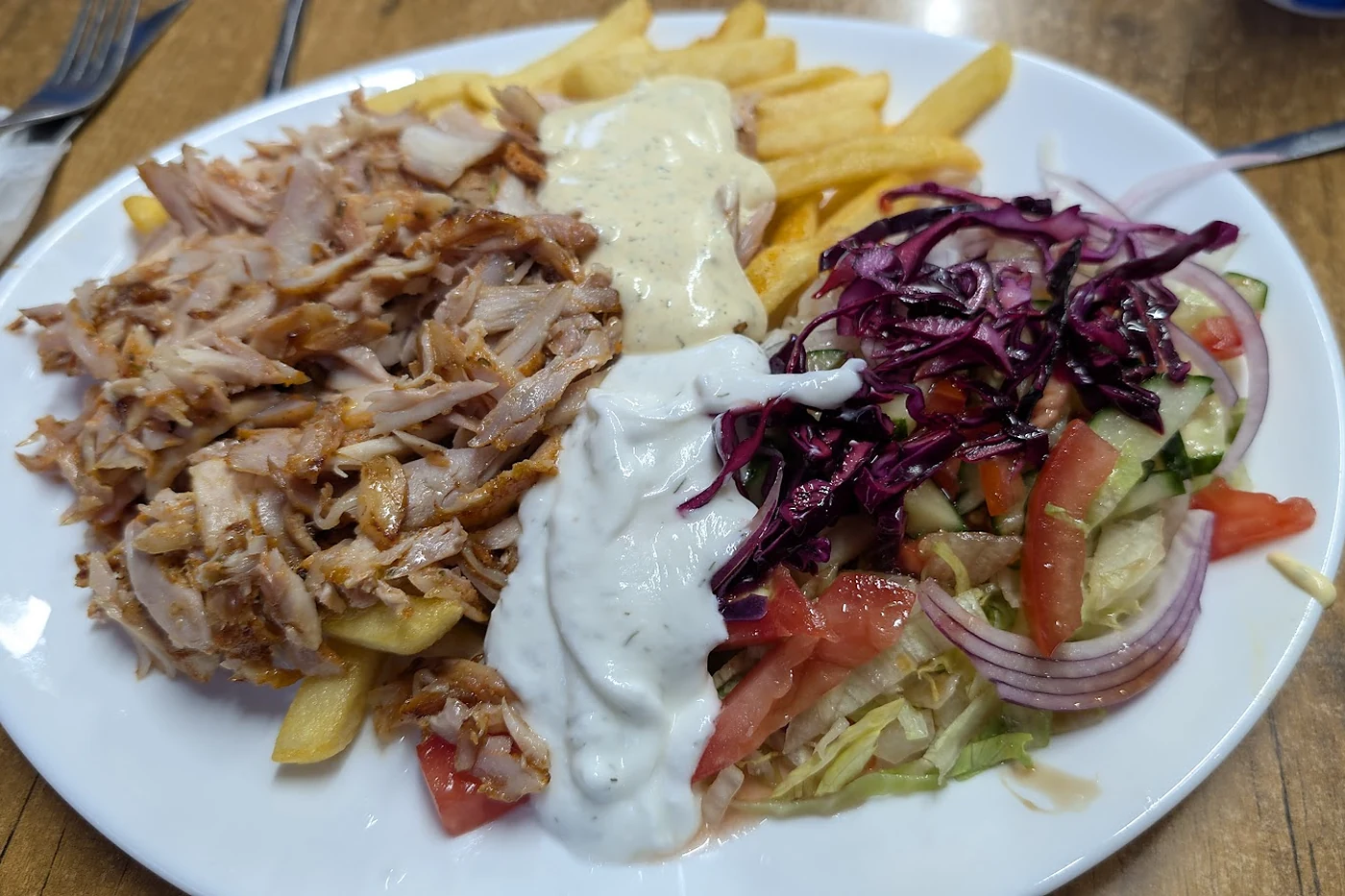 Salattheke mit Kraut, Tomaten und Beilagen hinter Glas