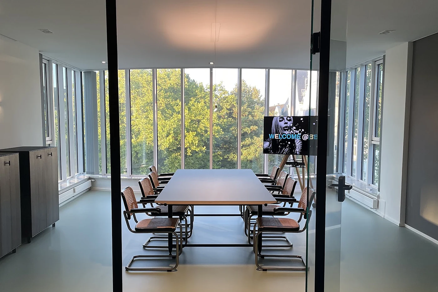 Konferenzraum mit langem Tisch hinter einer Glastür