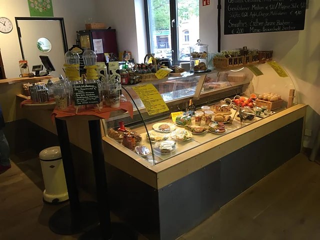 Café-Theke mit Kuchenvitrine, belegten Brötchen und Tafeln mit dem Tagesangebot