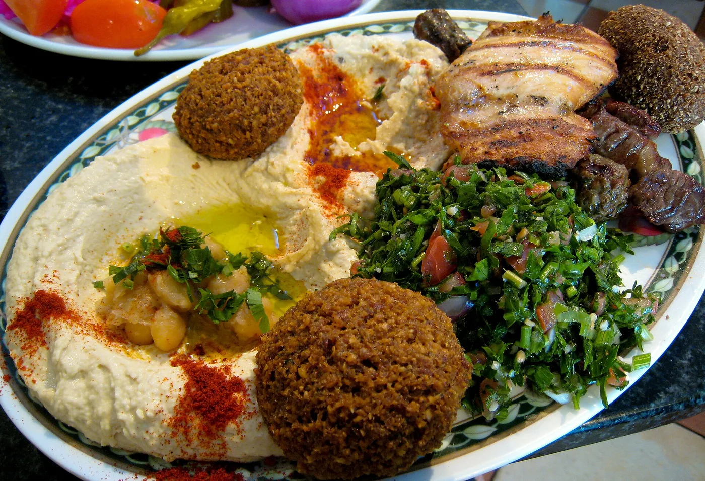 Platte mit Hummus, Falafel, Tabbouleh und gegrilltem Fleisch
