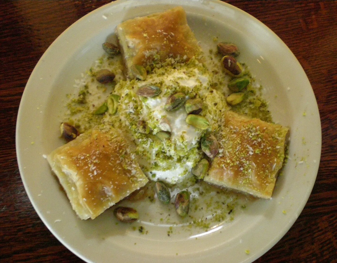 Baklawa mit gehackten Pistazien und Sahne auf einem Teller