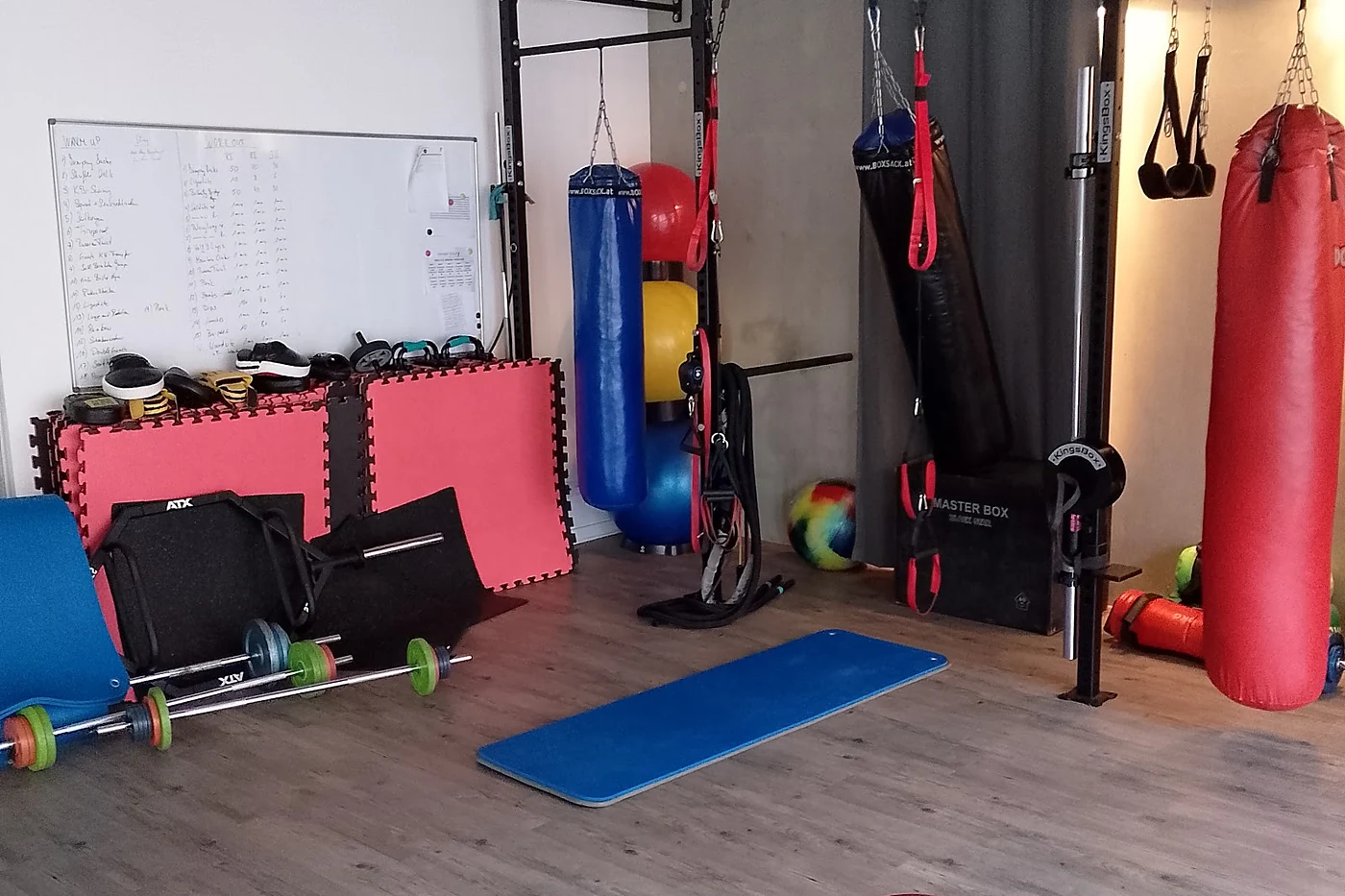 Trainingsraum mit Matten, Gymnastikball und Geräten an der Wand