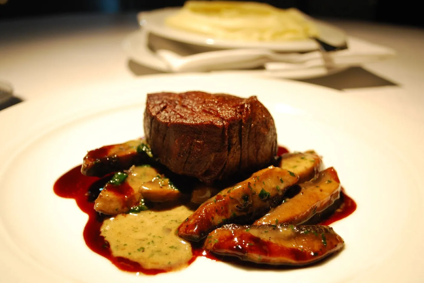 Rinderfilet mit Pilzen und Rotweinsauce auf weißem Teller