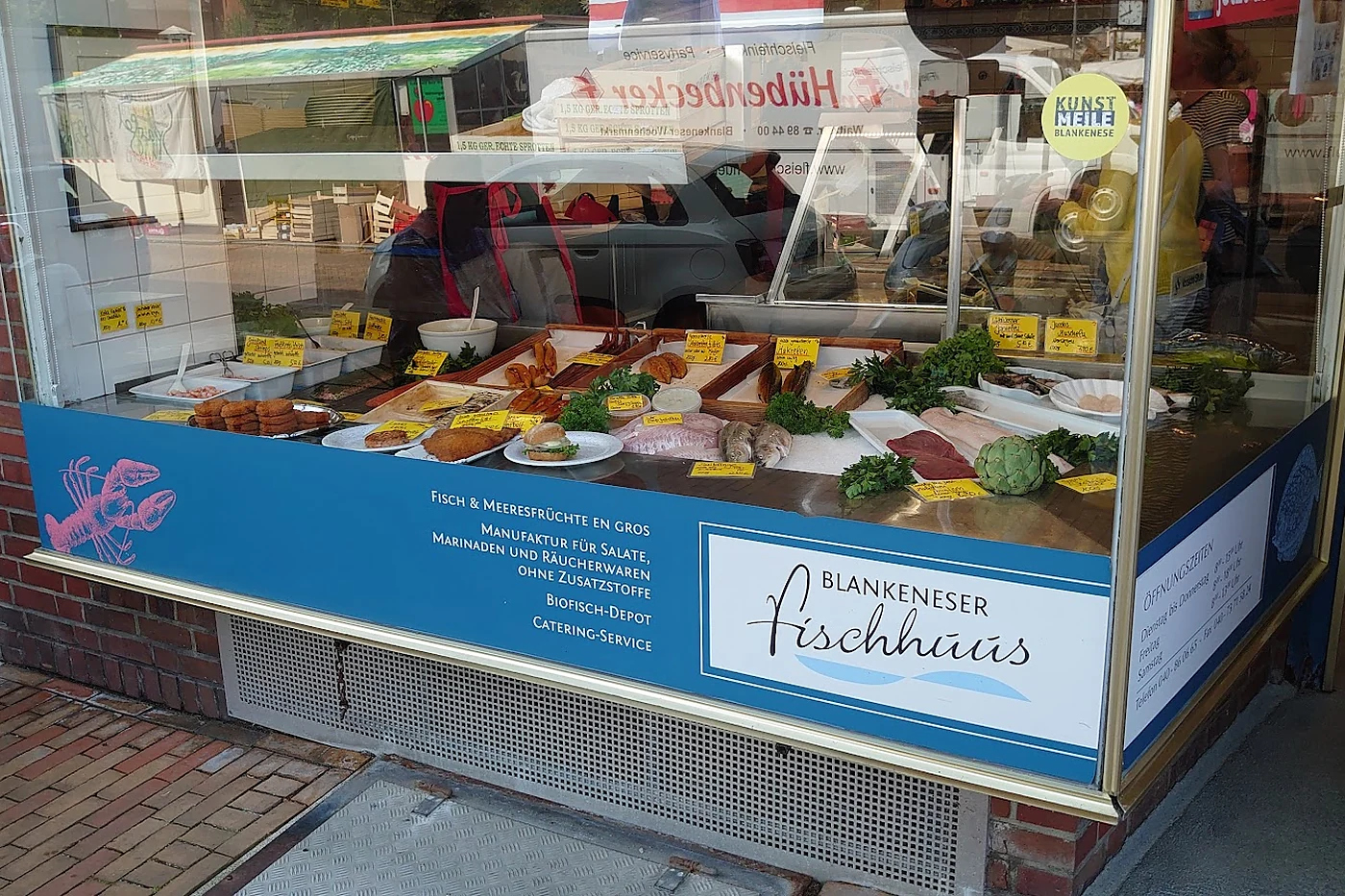 Auslage mit Fischbrötchen und Salaten hinter Glas