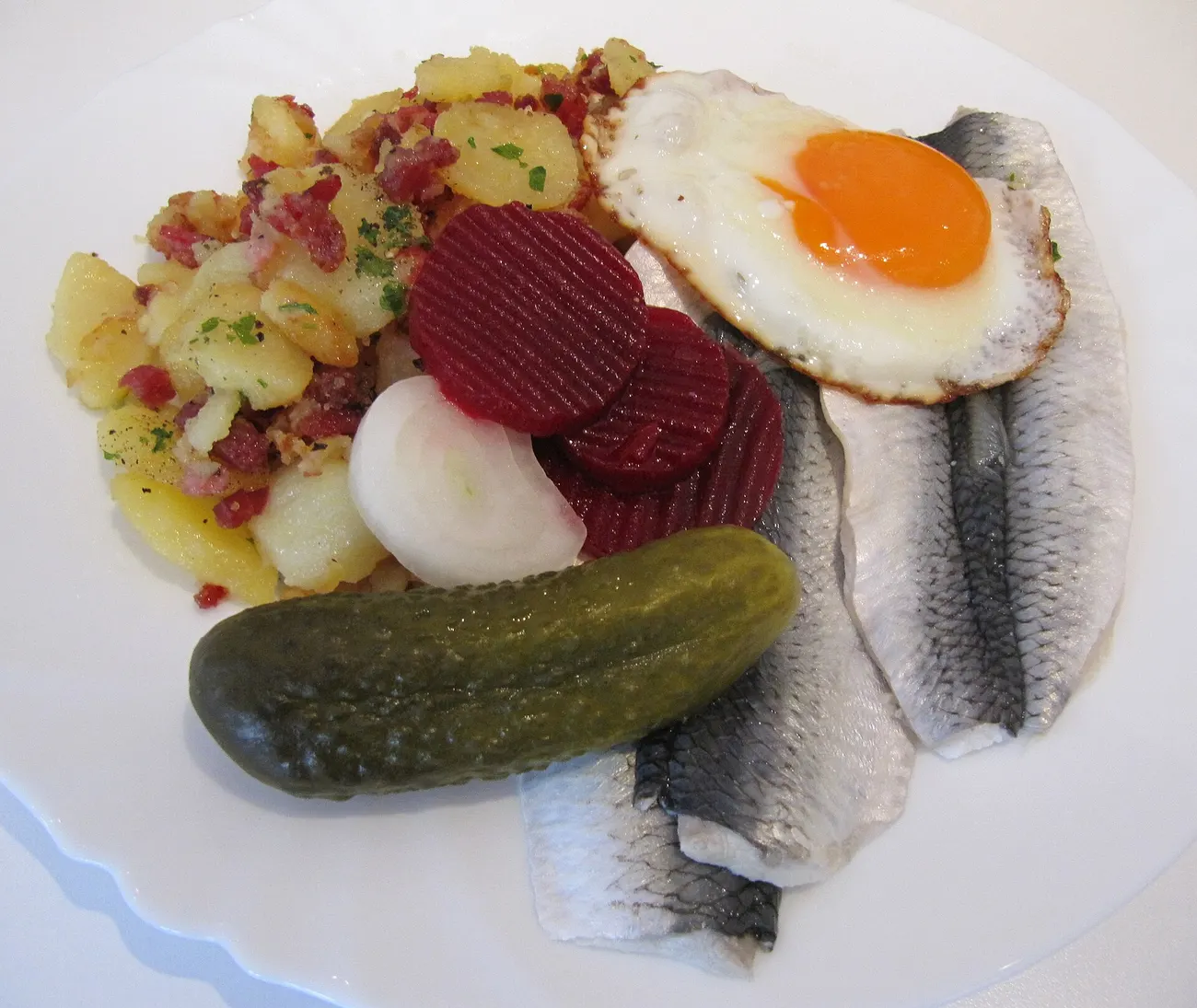 Heringsfilets mit Spiegelei, Bratkartoffeln, Roter Bete und Gewürzgurke