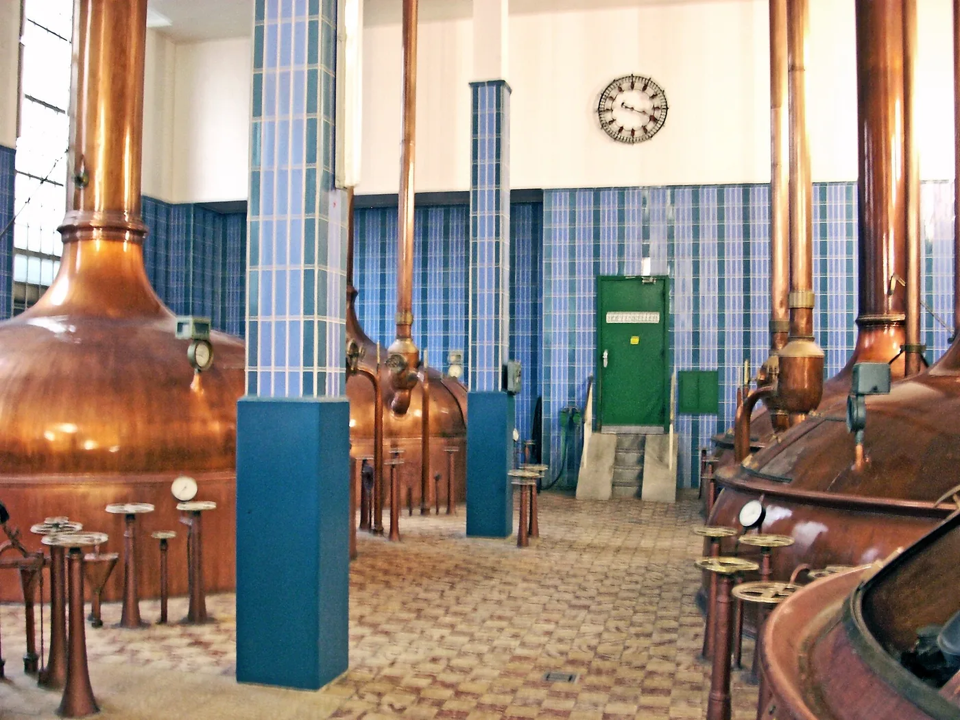 Sudhaus einer Brauerei mit kupfernen Sudkesseln und blauen Kacheln