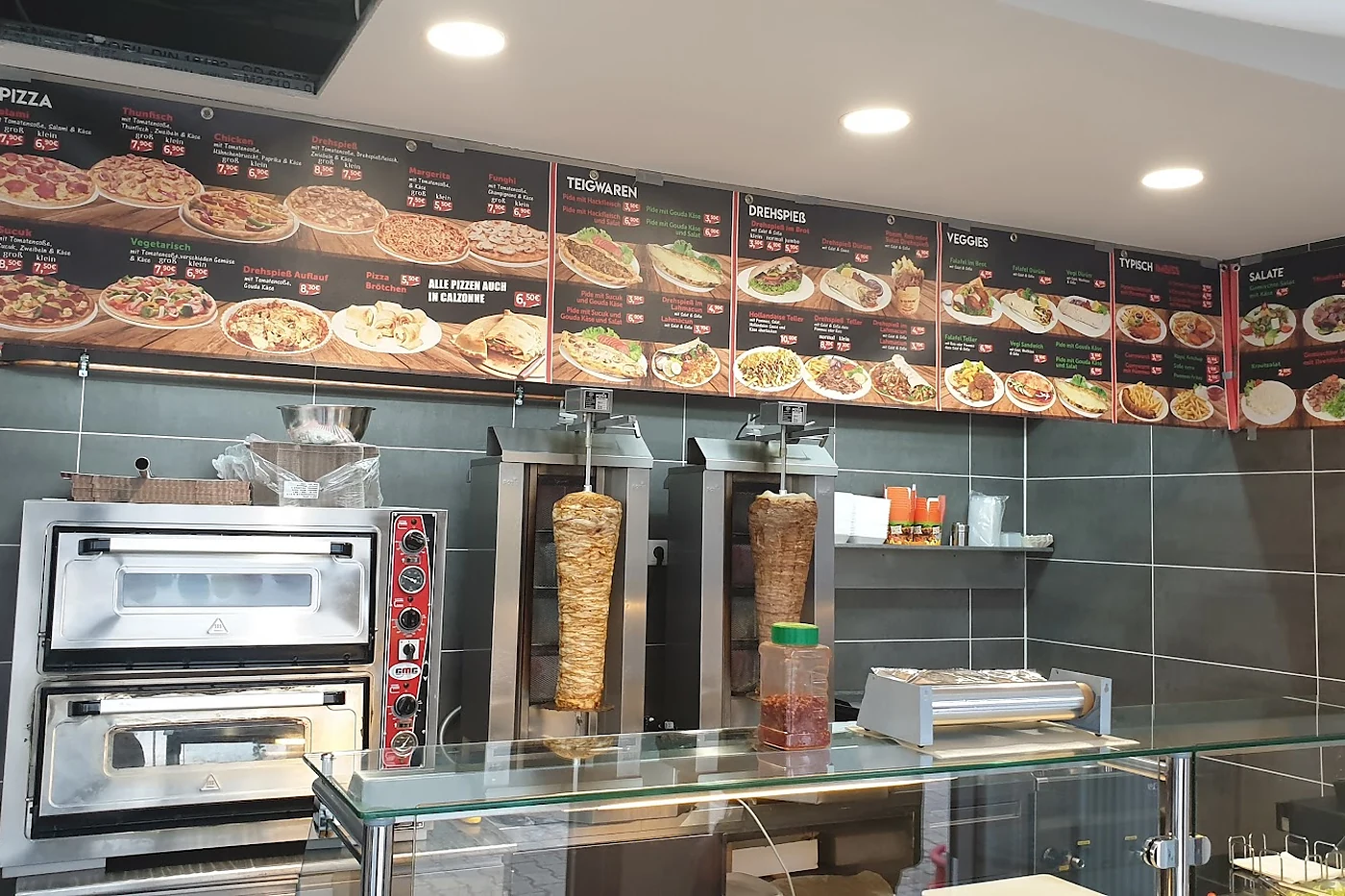 Pizzaofen und Dönerspieß hinter der Theke