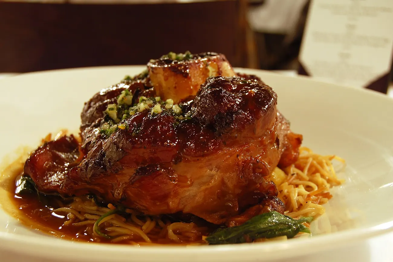 Geschmortes Ossobuco mit glasierter Sauce auf einem Bett aus Pasta