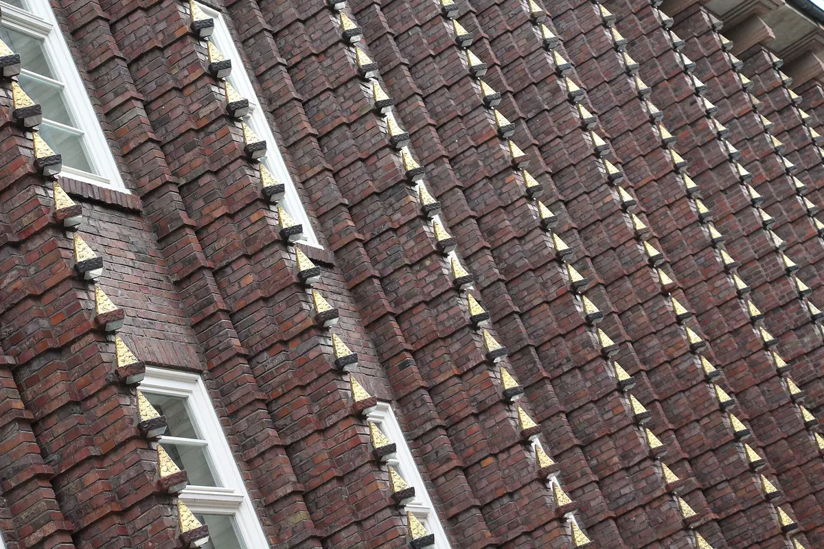 Backsteinfassade des Broschek-Hauses mit zackenförmigen Vorsprüngen und vergoldeten Spitzen