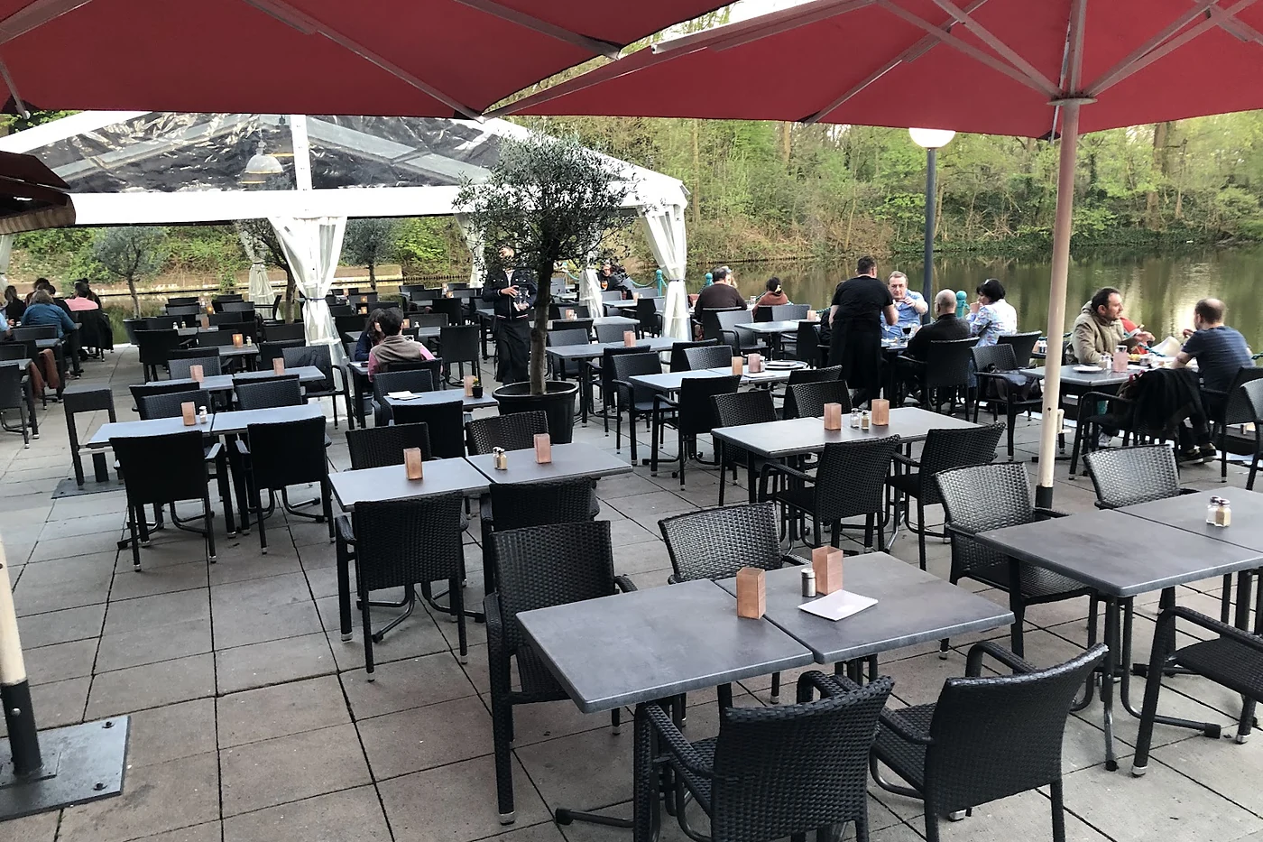 Tische unter roten Sonnenschirmen auf der Terrasse