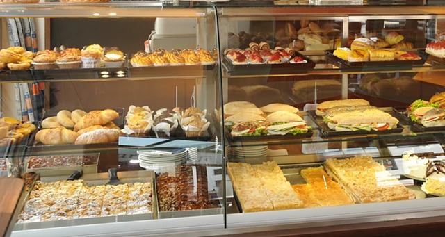 Kuchenvitrine mit Gebäck, belegten Brötchen und Blechkuchen