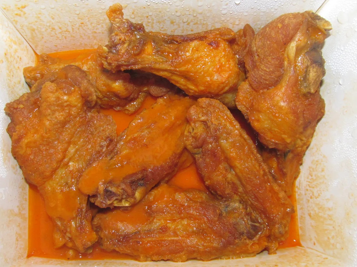 Frittierte Chicken Wings mit rötlicher Sauce in einer Schale