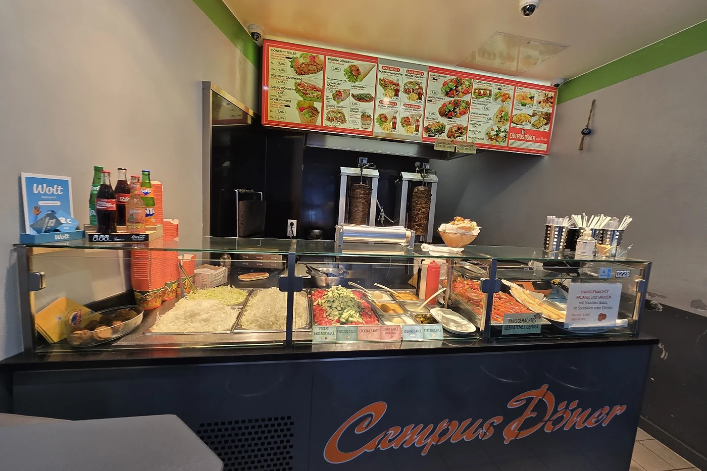 Theke mit Salatauslage und Menütafeln darüber