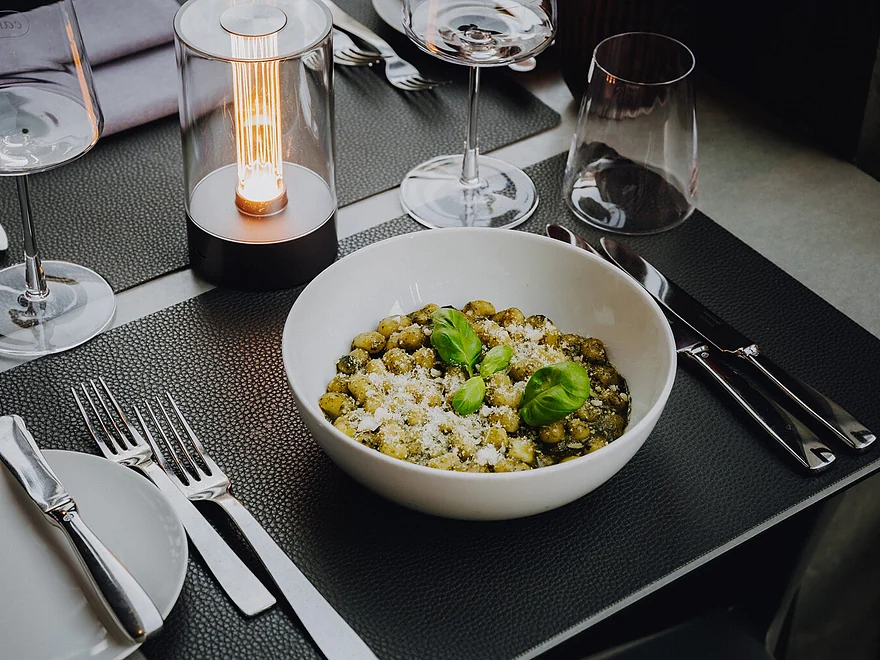 Gnocchi in grüner Kräutersauce mit Parmesan und Basilikum in weißer Schale