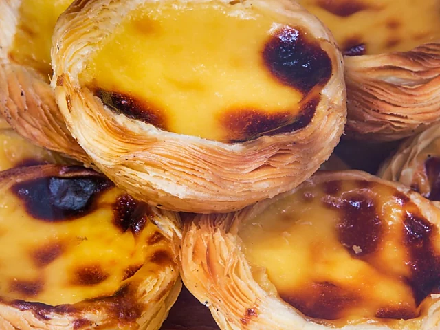 Nahaufnahme mehrerer Pastéis de Nata mit karamellisierter Vanillecreme und Blätterteigrand