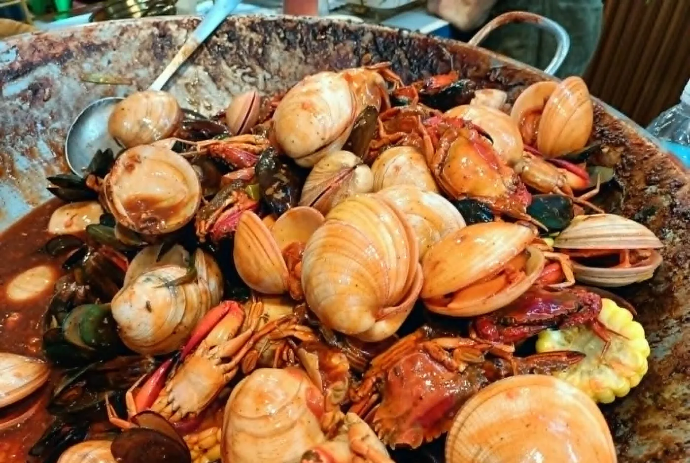 Große Pfanne mit Muscheln, Garnelen und weiteren Meeresfrüchten