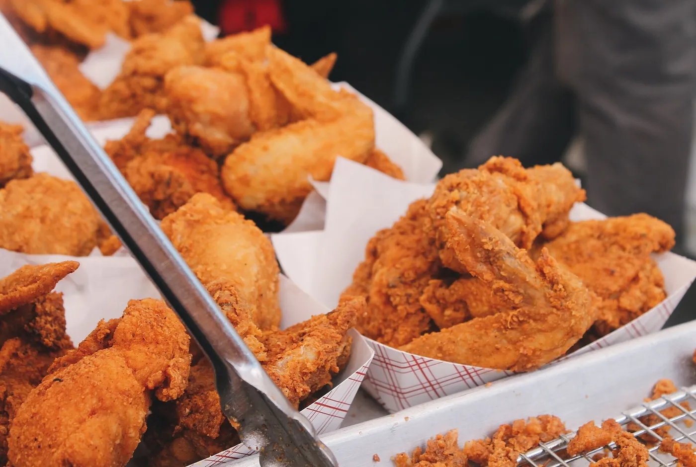 Frittierte panierte Hähnchenteile in Körben an einer Imbisstheke