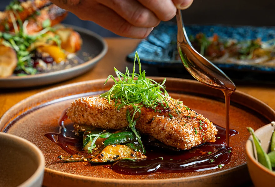 Gebackenes Tellergericht mit Frühlingszwiebeln, über das Sauce gegossen wird