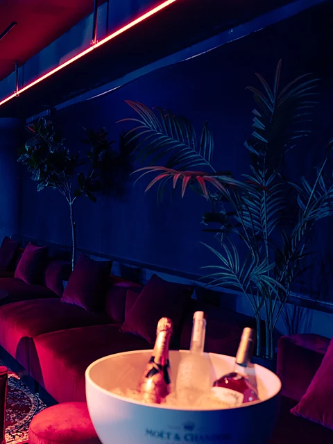 VIP-Bereich im CODA Hamburg mit roten Samtbänken, Tischlampen und Flaschenkühler