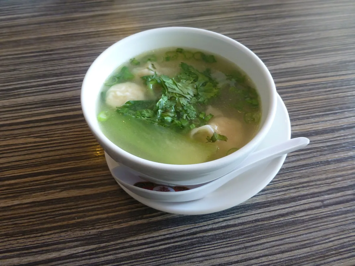 Schale Wan-Tan-Suppe mit Teigtaschen, Pak Choi und Koriander