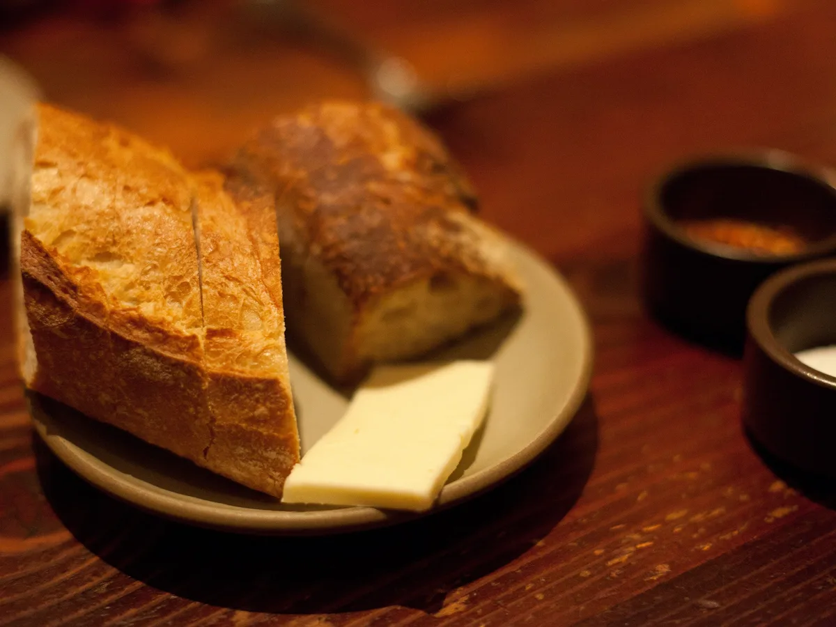 Aufgeschnittenes Weißbrot mit einem Stück Butter auf einem Teller