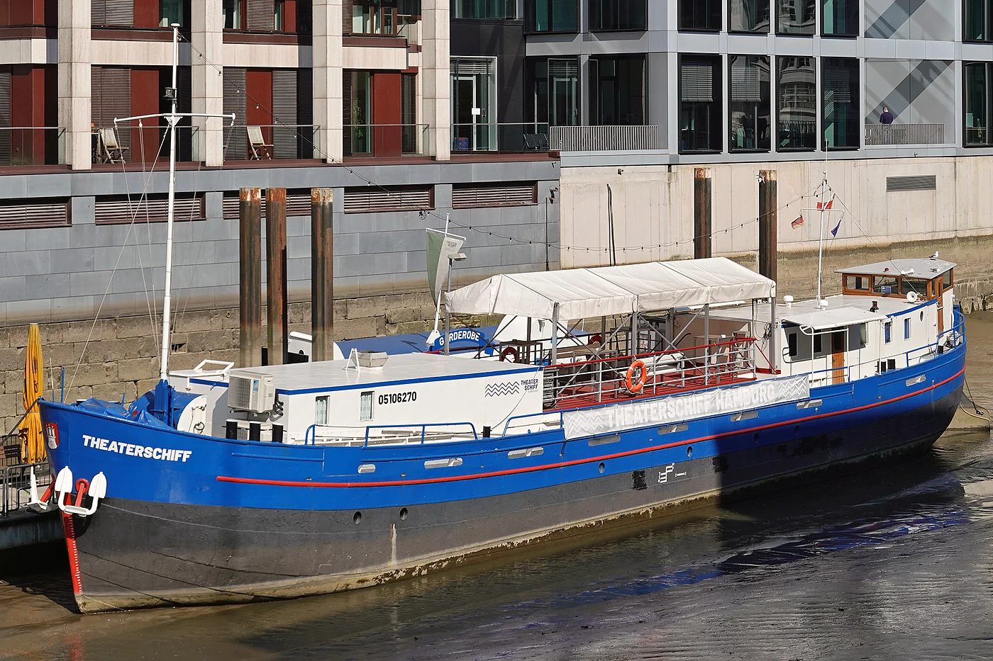 Das blaue Theaterschiff im Fleet vor den Fassaden der Altstadt