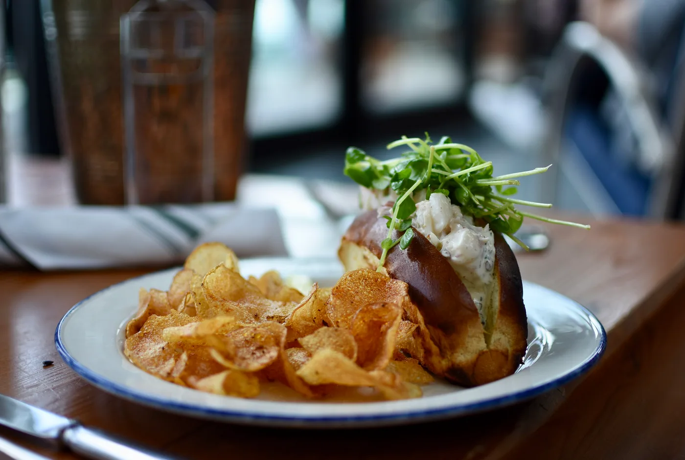 Lobster Roll mit Hummerfleisch und Kresse in einem Briochebrötchen, dazu Kartoffelchips