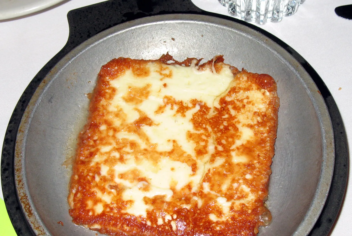 Gebratener Käse mit goldbrauner Kruste in einer kleinen gusseisernen Pfanne