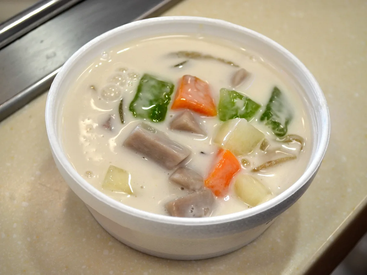 Vietnamesisches Dessert mit Kokosmilch, Taro, Süßkartoffel und grünem Gelee in einer Schale