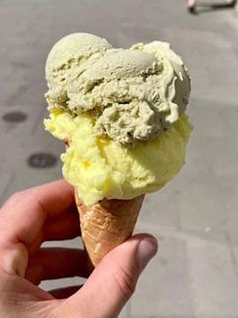 Eiswaffel mit Pistazien- und Vanilleeis in der Hand