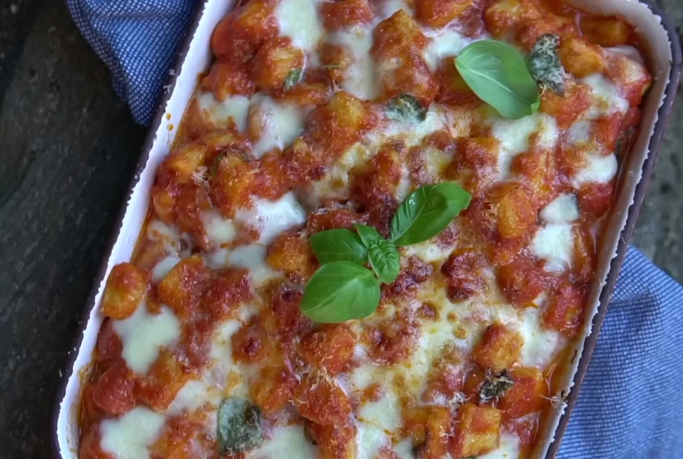 Überbackene Gnocchi mit Tomatensauce, Mozzarella und Basilikum in einer Auflaufform