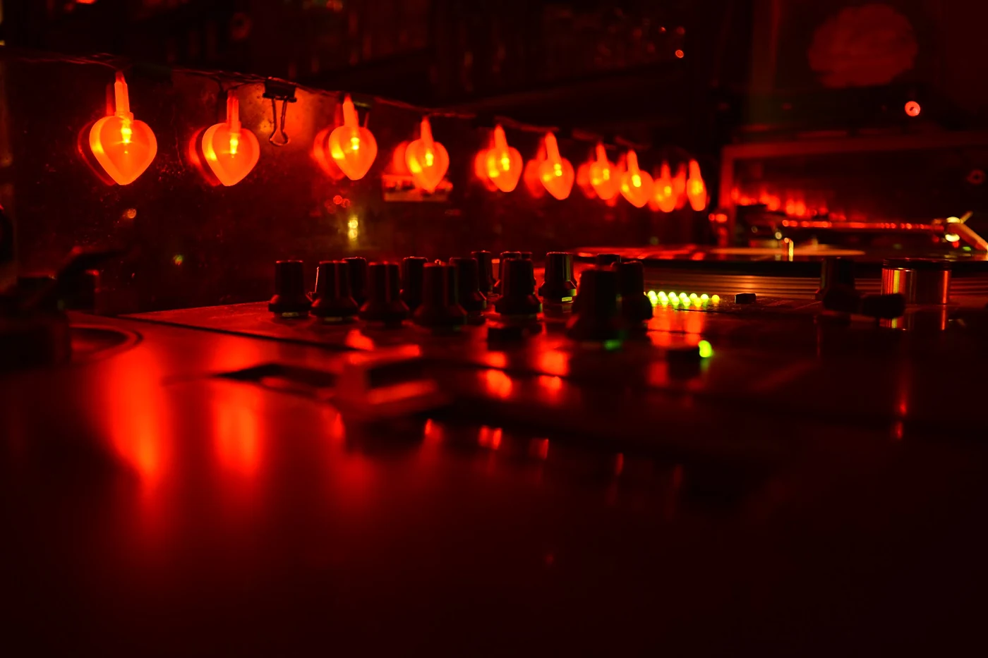 Kette herzförmiger roter Lämpchen über dem DJ-Pult des Le Fonque mit Mischpult und Plattenspieler