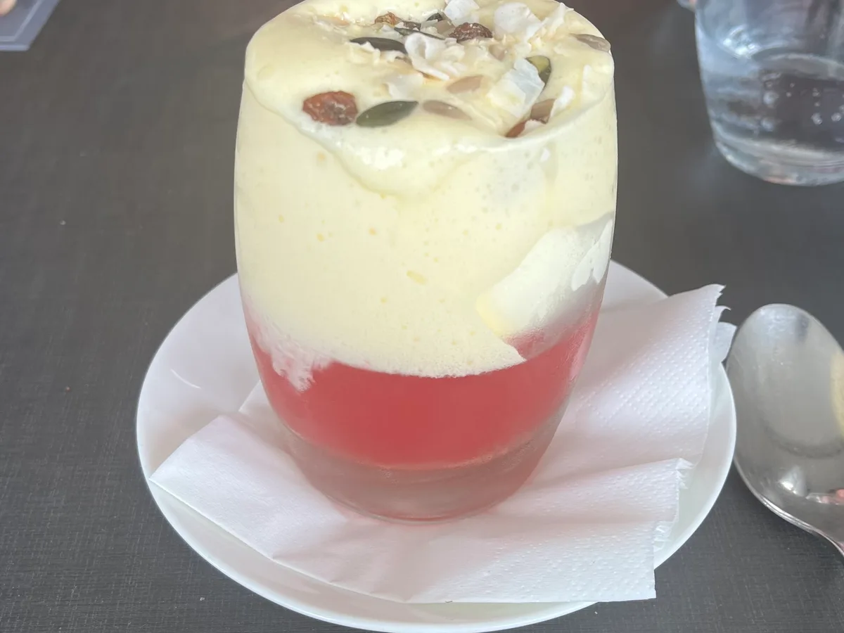 Dessert im Glas mit Rhabarberkompott, heller Creme und Kernen als Garnitur