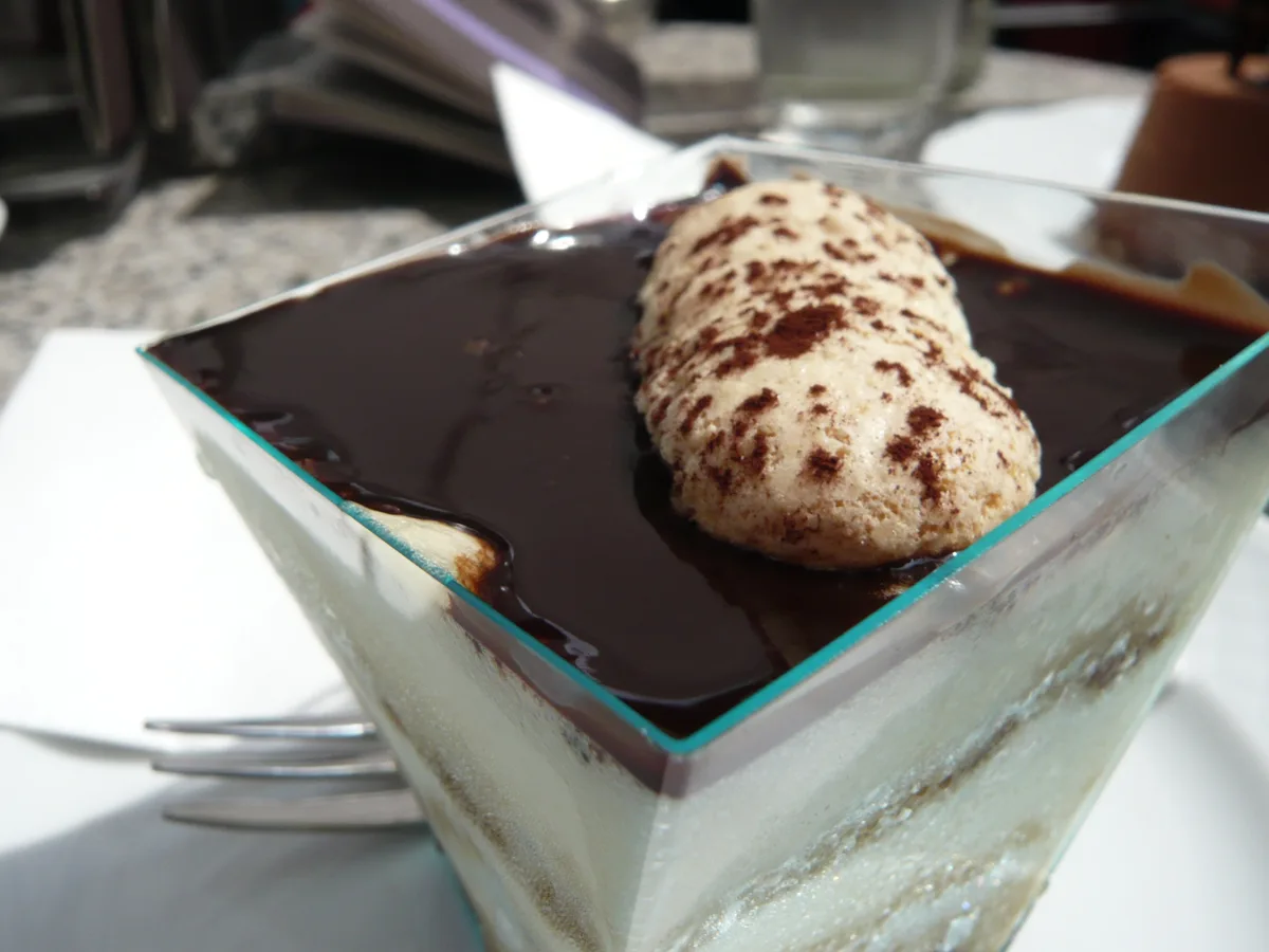 Tiramisu in einem eckigen Glas mit Schokoladenspiegel und Kakaopulver
