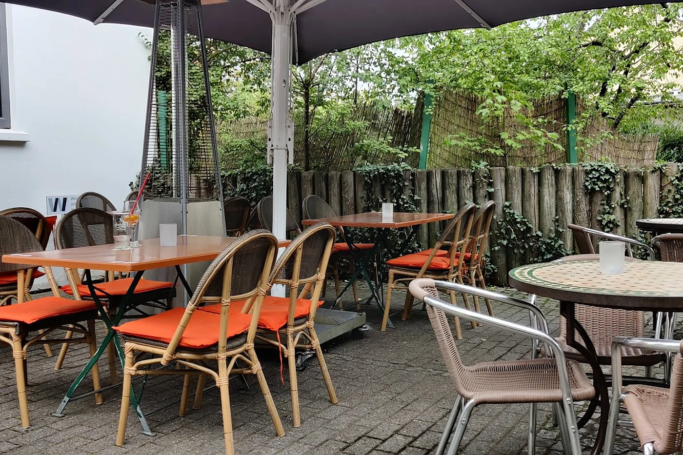 Terrasse mit orangefarbenen Stühlen unter einem Dach