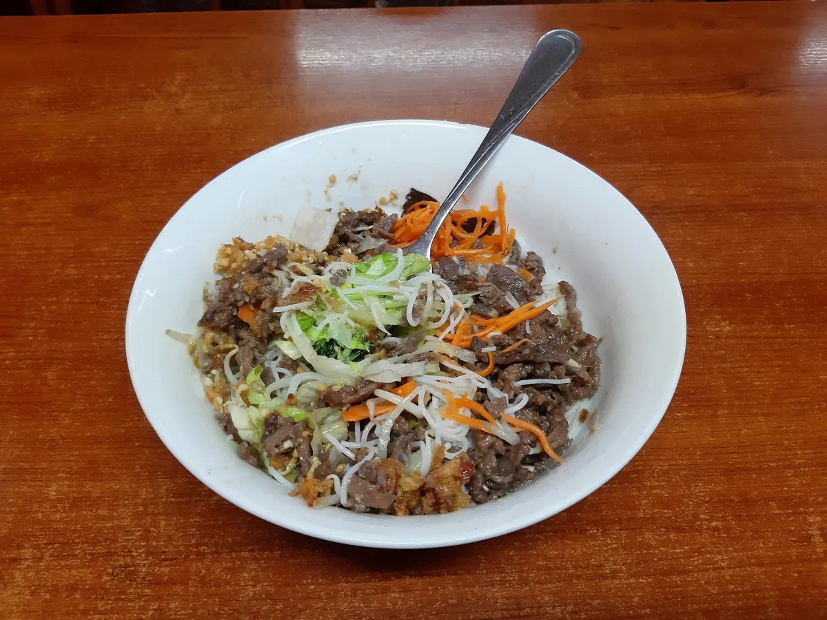 Schale Bun Bo mit Reisnudeln, gebratenem Rindfleisch, Karottenstreifen und Salat