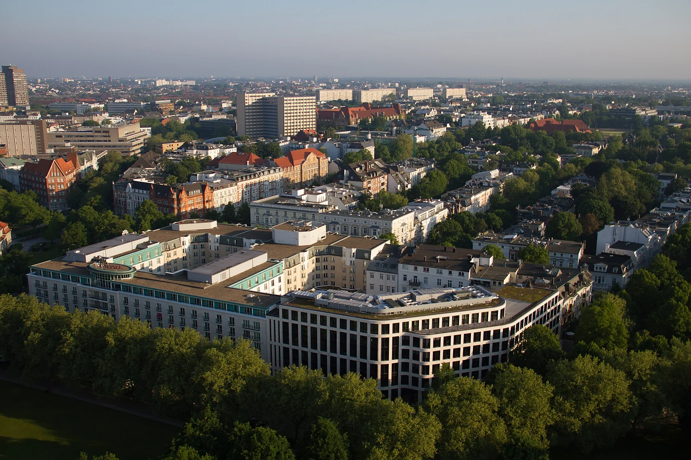 Luftbild des Hotelblocks mit begrüntem Innenhof zwischen Gründerzeithäusern