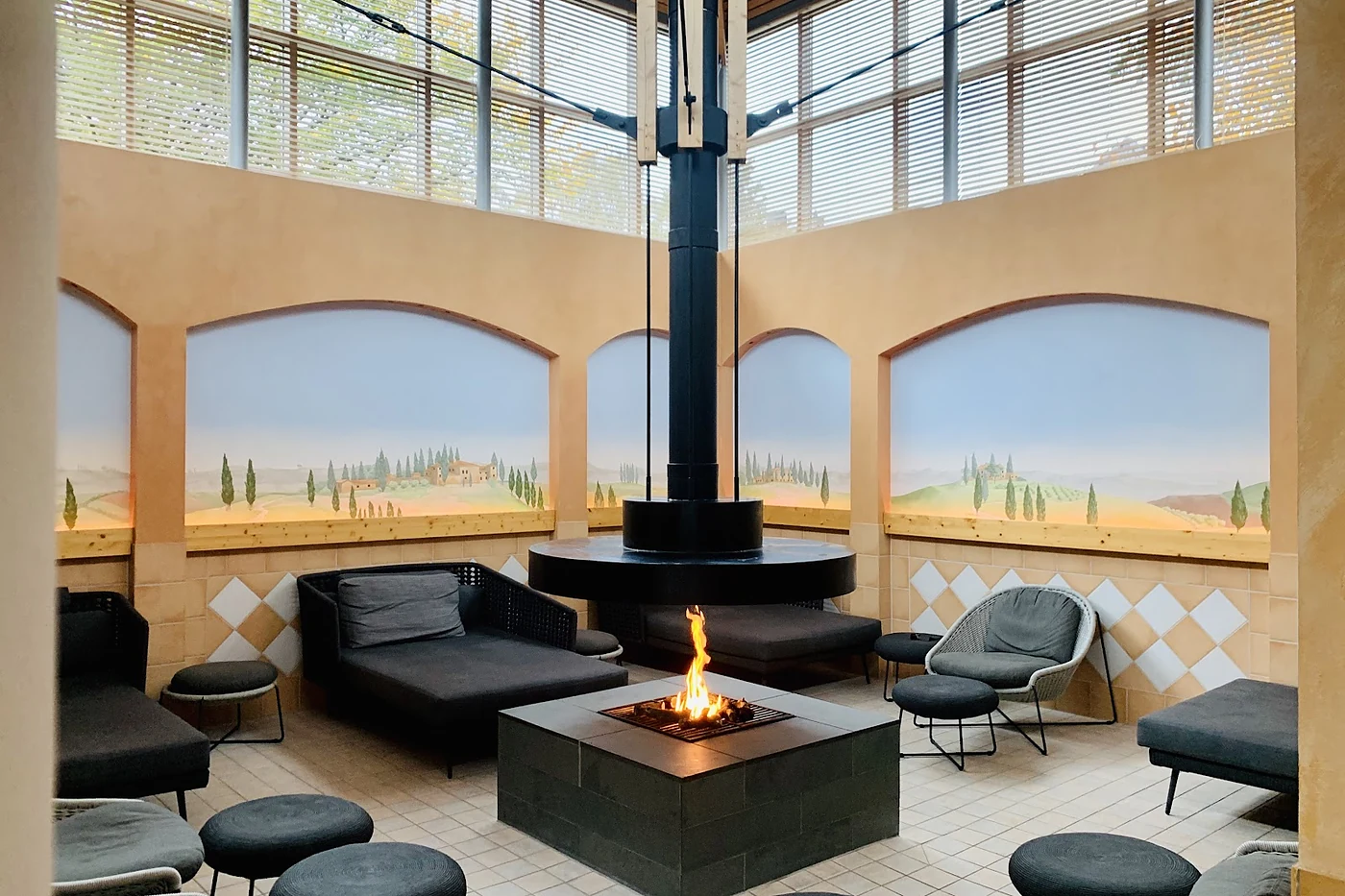 Lounge mit offener Feuerstelle, Sesseln und Hockern