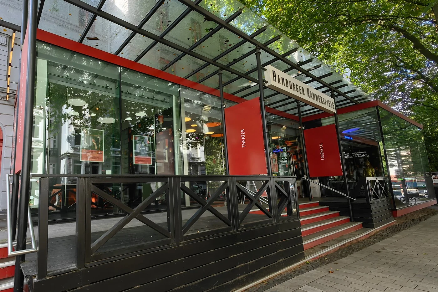 Verglastes Foyer mit rotem Stahlrahmen und Treppe